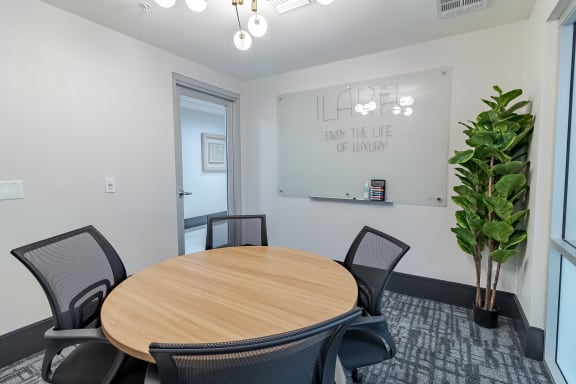 a conference room with a round table and a large plant