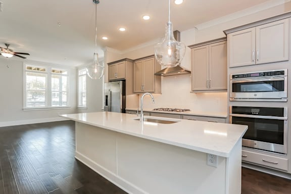 A modern kitchen with a white island and stainless steel appliances.