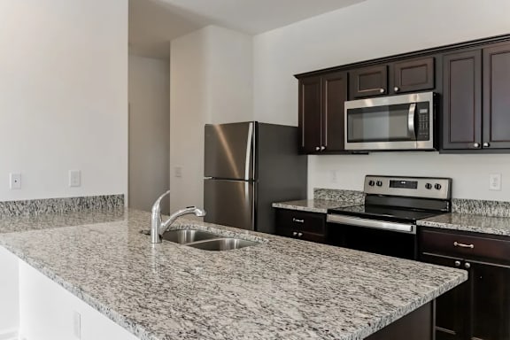 A kitchen with granite countertops and stainless steel appliances.