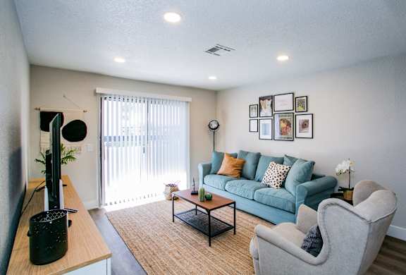 A living room with a blue couch and a coffee table.