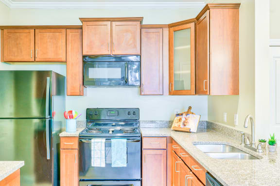 a kitchen with wood cabinets and stainless steel appliances