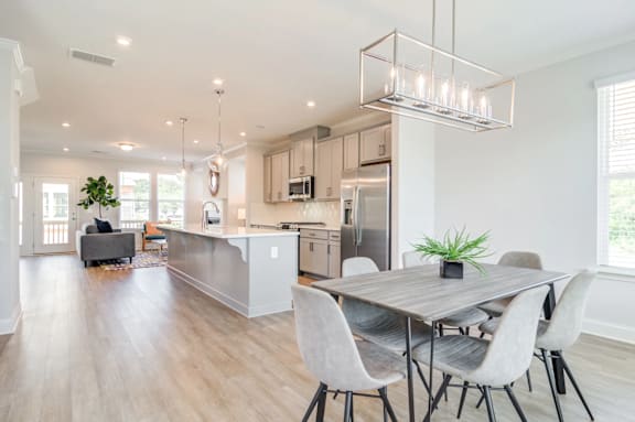 A modern kitchen with a dining table and chairs.