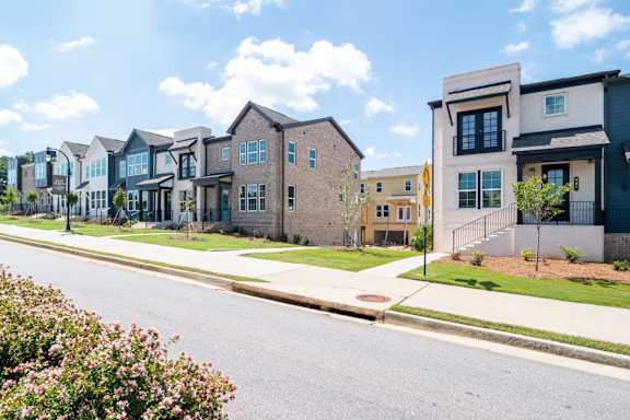 A row of houses with a street in front.