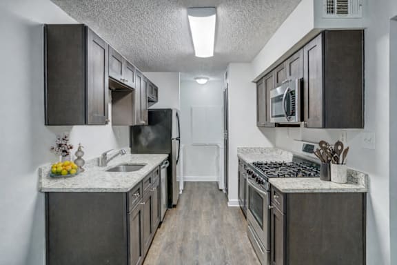 A kitchen with dark wood cabinets and stainless steel appliances.