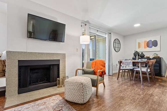 A living room with a fireplace and a television mounted on the wall.