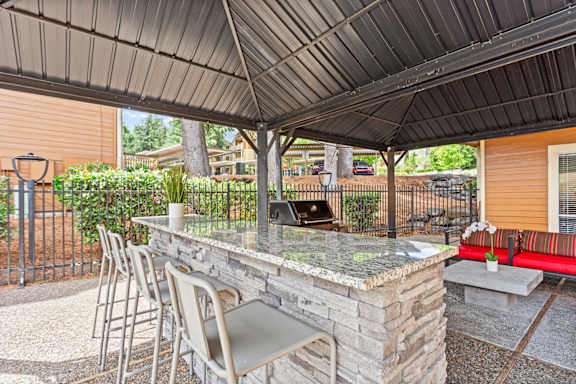 A patio with a bar and chairs under a roof at MonteVista Apartments, Oregon 97007