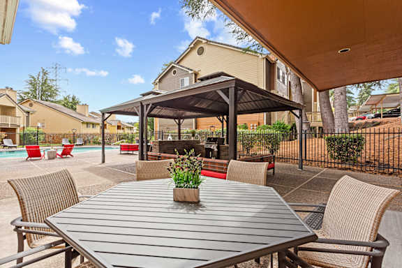 A patio with a table and chairs under a canopy at MonteVista Apartments, Oregon
