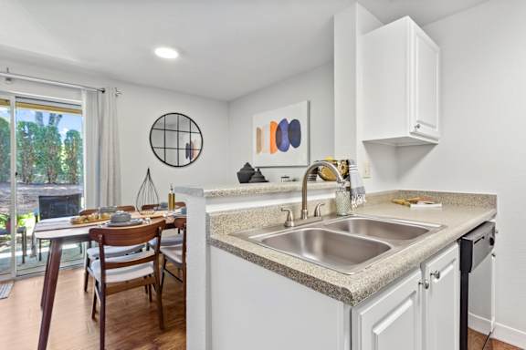 A kitchen with a table and chairs by a window.
