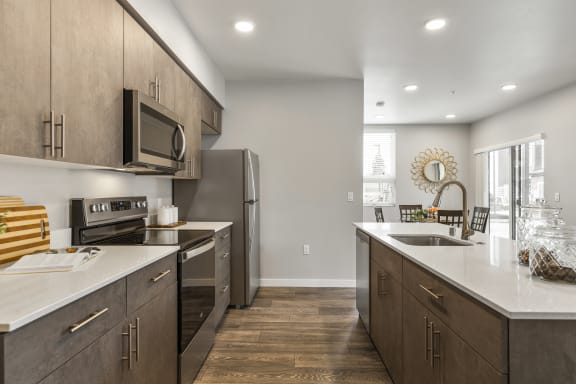 Apartments for rent in Tacoma, WA - Pacific Ridge - kitchen with stainless-steel appliances, quartz countertops, and sleek designed cabinets,