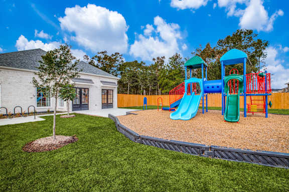 A playground with a blue slide and a green slide.