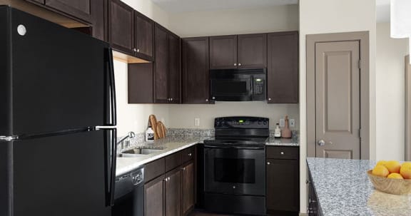 a kitchen with a black stove top oven next to a refrigerator