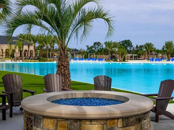 A pool area with a hot tub and chairs.