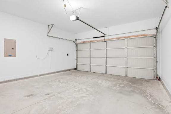 A white garage with a white door and a white ceiling.
