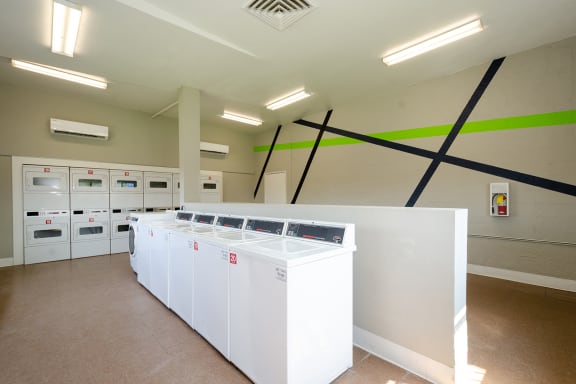 a laundry room with white washers and dryers