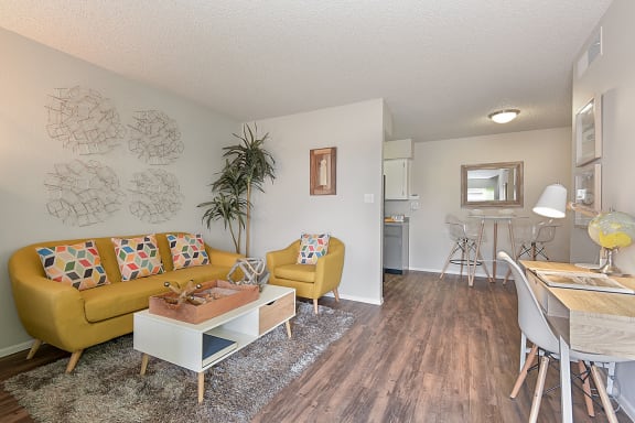 a living room with a yellow couch and a white coffee table