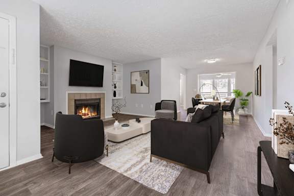 A living room with a fireplace and two chairs.