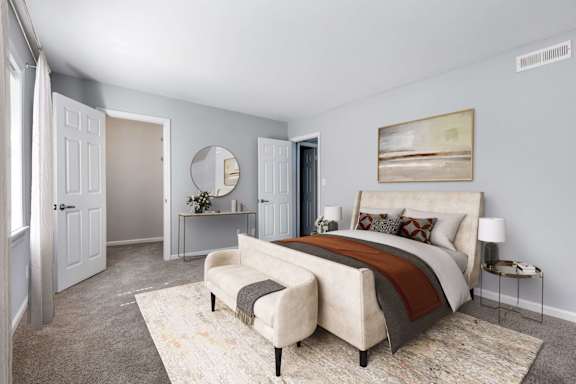 A bedroom with a large bed and a mirror on the wall.