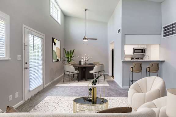 A modern living room with a dining area and kitchen in the background.