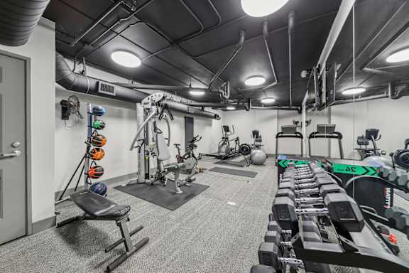 A gym with a variety of equipment including weights and machines.