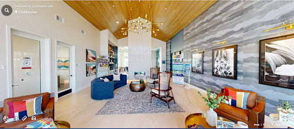 A living room with a wooden ceiling and a grey stone wall.