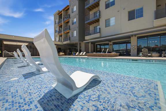A pool with a blue tiled edge and a white sculpture in the middle.