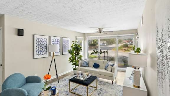 A living room with a blue chair, a white couch, and a coffee table.