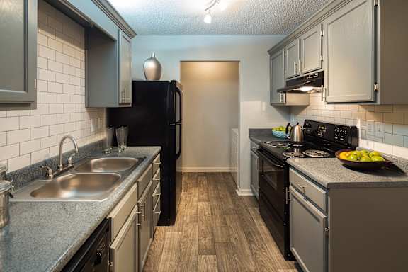 A kitchen with a black refrigerator and stove.
