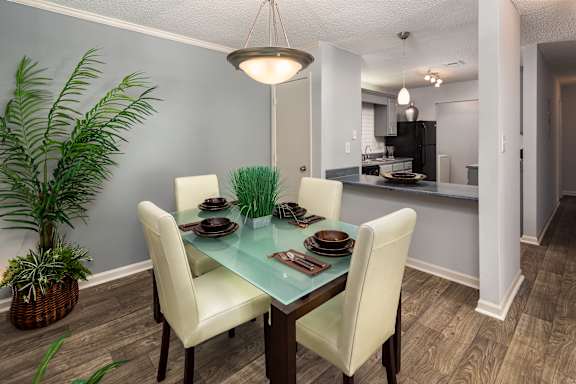 A dining room with a glass table and chairs.