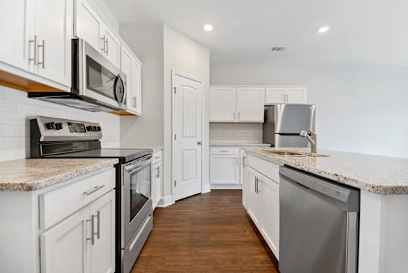 A kitchen with white cabinets and stainless steel appliances.
