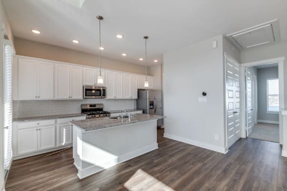 A modern kitchen with white cabinets and a central island.