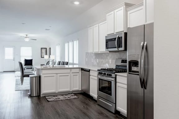 A modern kitchen with stainless steel appliances and white cabinets.