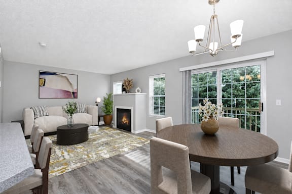 A modern living room with a fireplace and a dining table set for four.