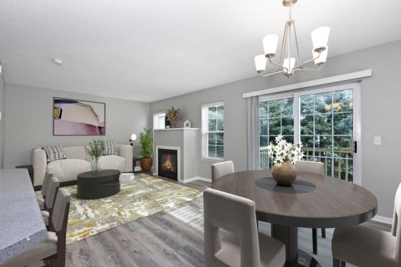 Summit Townhomes in Burnsville, MN photo of a living room and dining room with a fireplace and a table and chairs