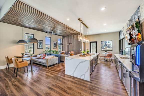 A modern kitchen with a white island and wooden floors.