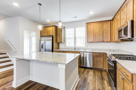 A kitchen with wooden cabinets and a granite countertop.