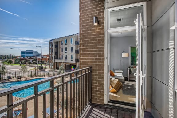 a balcony with a pool and a view of the city