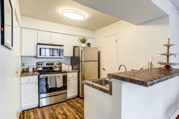 Glendale Heights Apartments - The Mark - kitchen with stainless steel appliances and a granite counter top and wood plank floors