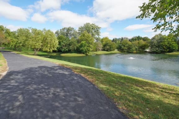 Glendale Heights Apartments - The Mark - a lovely walking trail next to a tranquil pond in a lush green park like setting