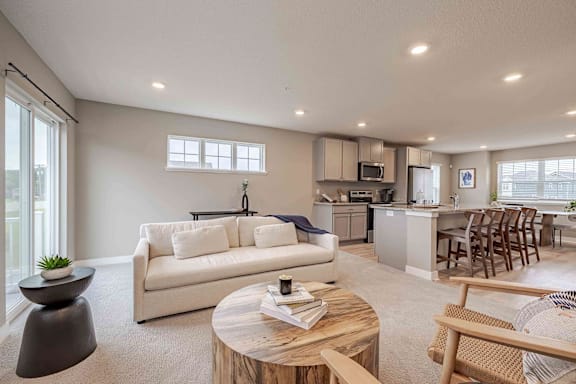 A living room with a white couch and a wooden coffee table.