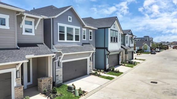 A row of houses with garages and driveways.