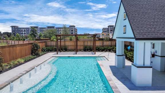 A small pool in a backyard with a wooden fence.