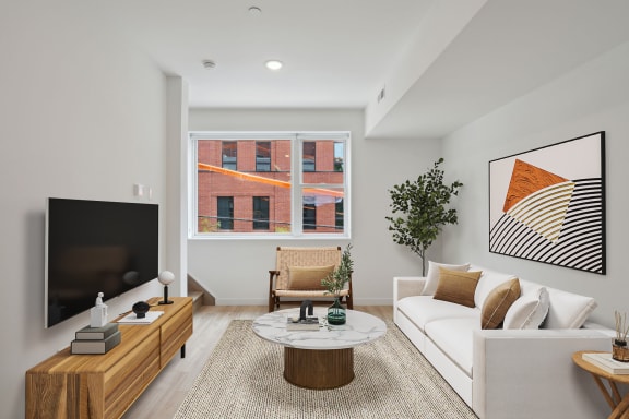 a living room with a white couch and a television