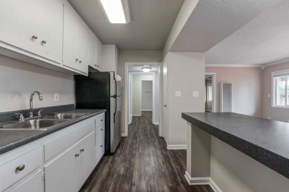 a kitchen with white cabinets and black appliances