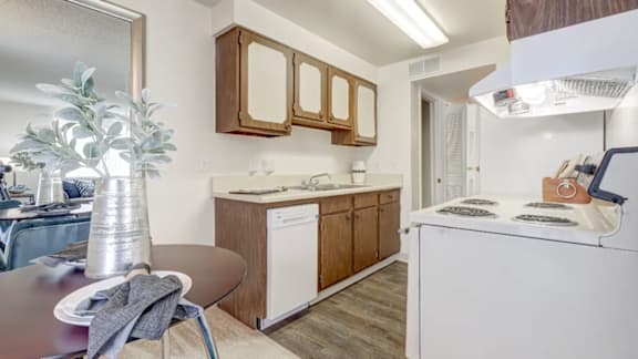 A kitchen with a white dishwasher and a white oven.