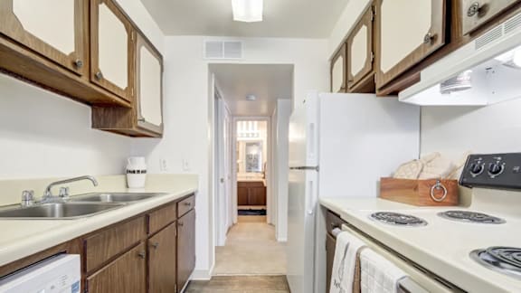 A kitchen with wooden cabinets and a white fridge.