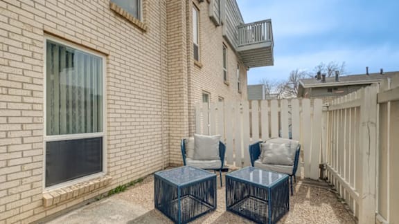 A patio with two chairs and a table.