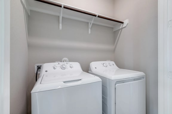 Two white front loading washing machines in a laundry room.