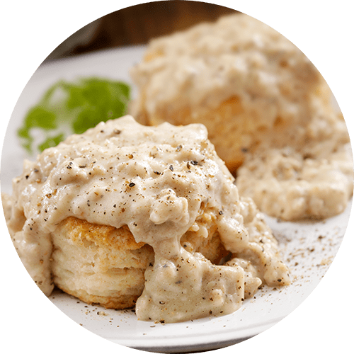 Plate of biscuits covered in gravy and pepper.