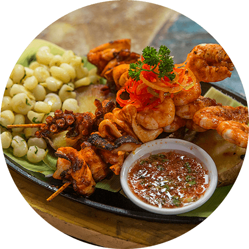A plate of fried chicken wings and two red chili peppers.