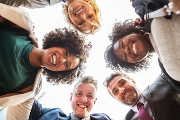 A group of people standing in a circle, looking up at the camera.